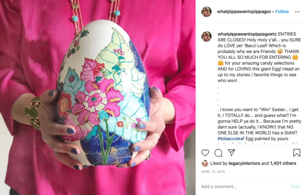 Mulher segurando um ovo com pintura de flores para concursos de Páscoa no Instagram