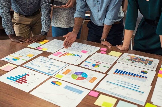 A team looking at the website improvement goal achievements and metrics on the table