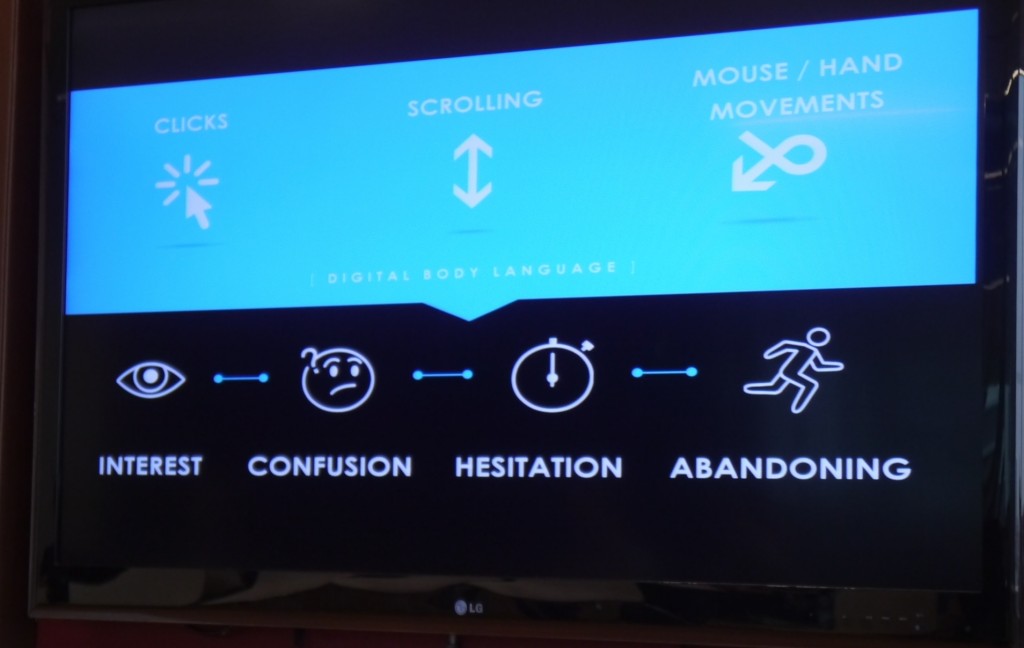Reactfulデジタルボディランゲージのプレゼンテーション画面の写真。青い吹き出しに一連の記号が表示されています。 1つは、CLICKSというタイトルの一連の線が放射状に広がるマウスポインタを示しています。もう1つは、SCROLLINGというラベルの付いた上下両方を指す矢印を示しています。ねじれた矢印には、MOUSE / HANDMOVEMENTSというラベルが付いています。吹き出しの下には、黒の背景に白の4つの記号があり、デジタルボディ言語を表しています。目の写真には「INTEREST」というラベルが付いています。不確かな顔と疑問符の写真には、CONFUSIONというラベルが付いています。ストップウォッチの写真にはHESITATIONというラベルが付いており、その後にABANDONINGというラベルの付いたランニングフィギュアが続きます。
