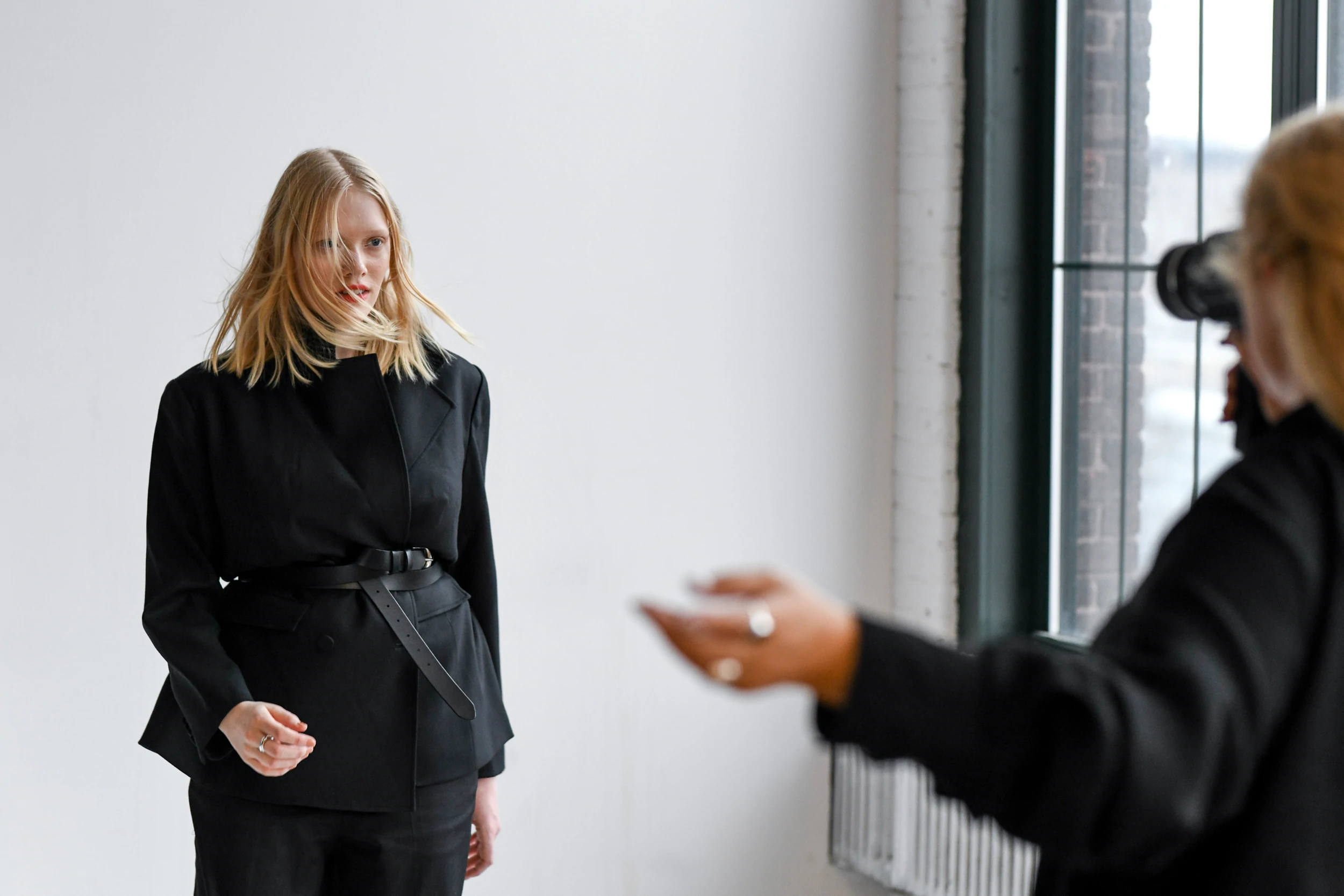 La modella bionda posa per un servizio fotografico indossando un cappotto nero