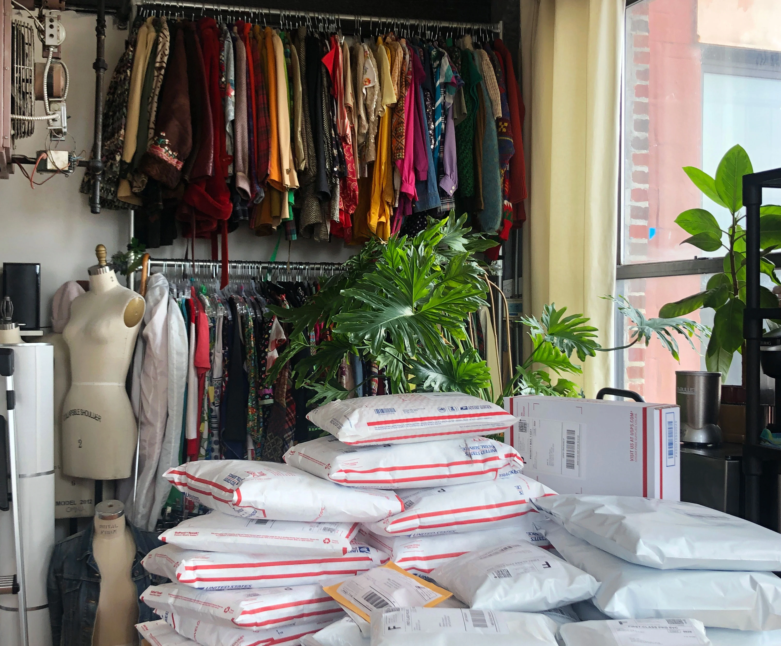 A store room filled with vintage clothing and packaged orders ready to be mailed