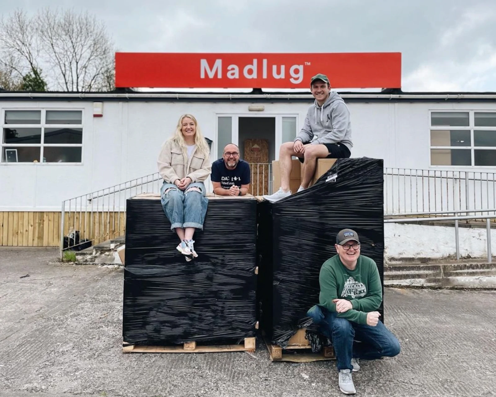 Dave Linton et les membres de son équipe posent avec une commande nouvellement expédiée devant le bureau de Madlug en Irlande du Nord.