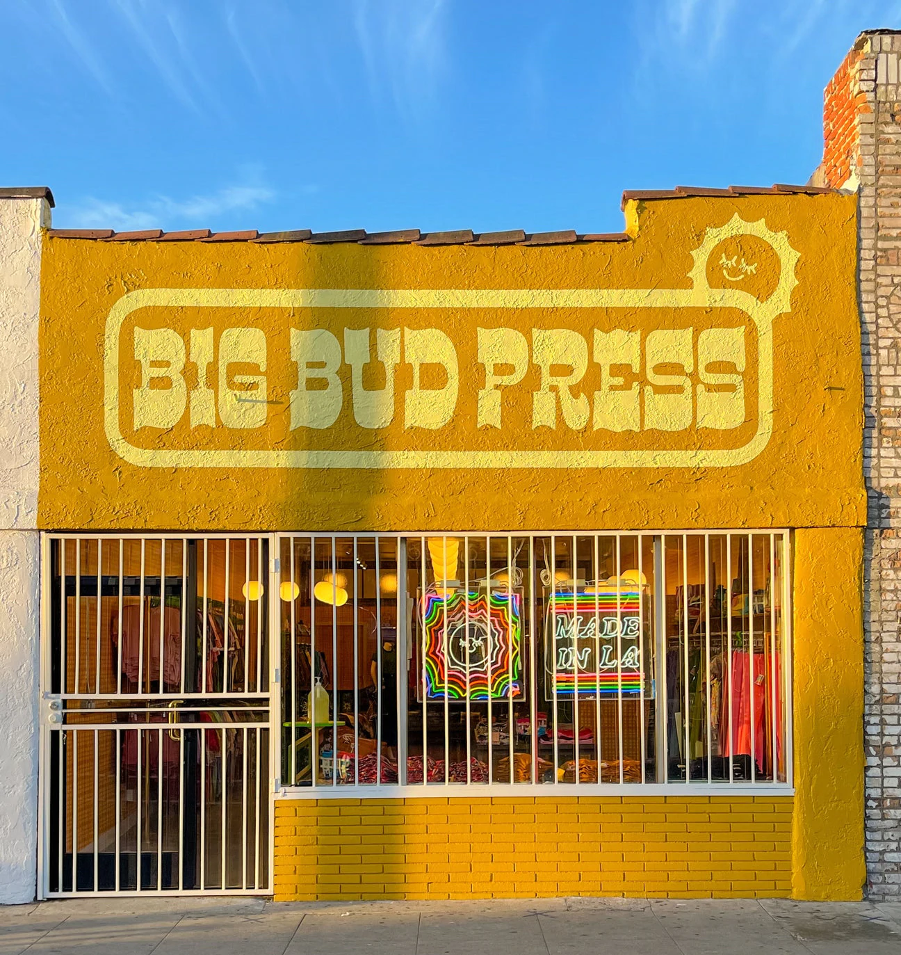 亮黃色和赭色的零售店面，上面寫著“BIG BUD PRESS”