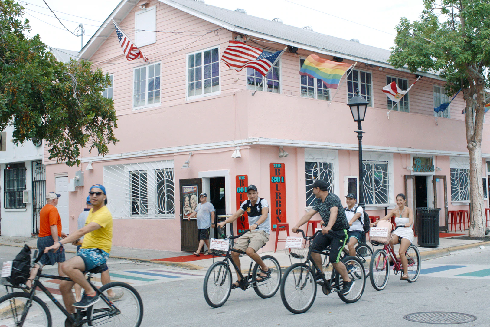 Un grup de oameni pe lângă o clădire roz din Key West, Florida