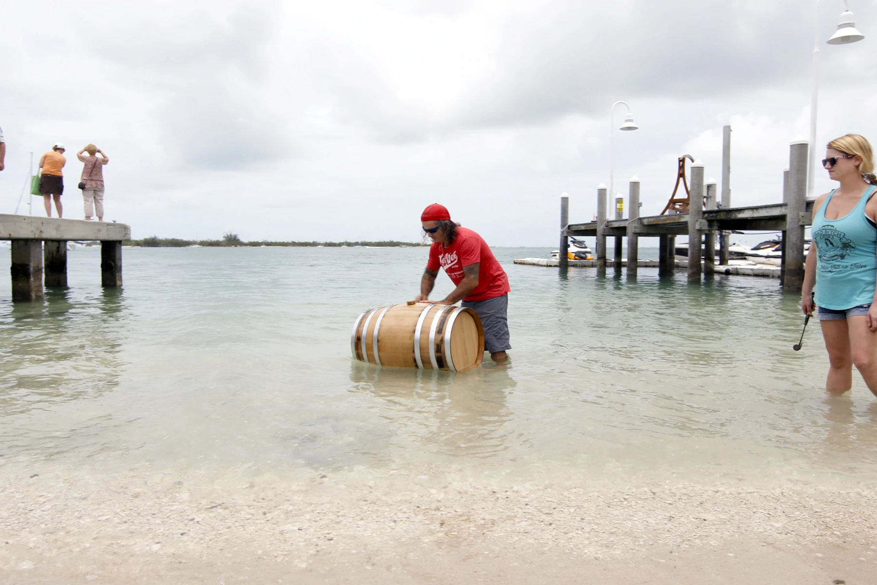 Paul Menta de la Key West Legal Rum Distillery scufundă un butoi de lemn în apă sărată de mică adâncime.