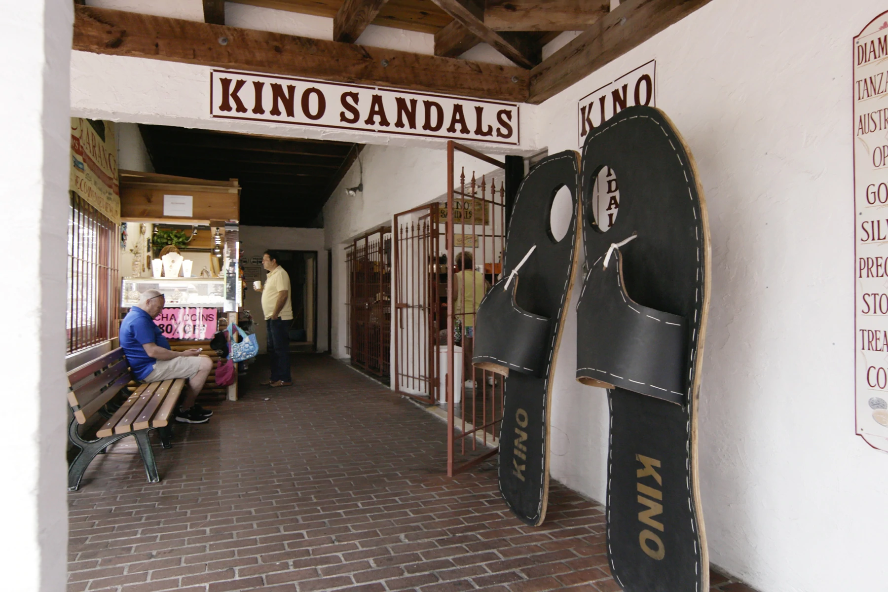 Exteriorul sandalelor Kino din Key West, Florida. Două sandale supradimensionate se sprijină pe peretele de lângă ușa magazinului.