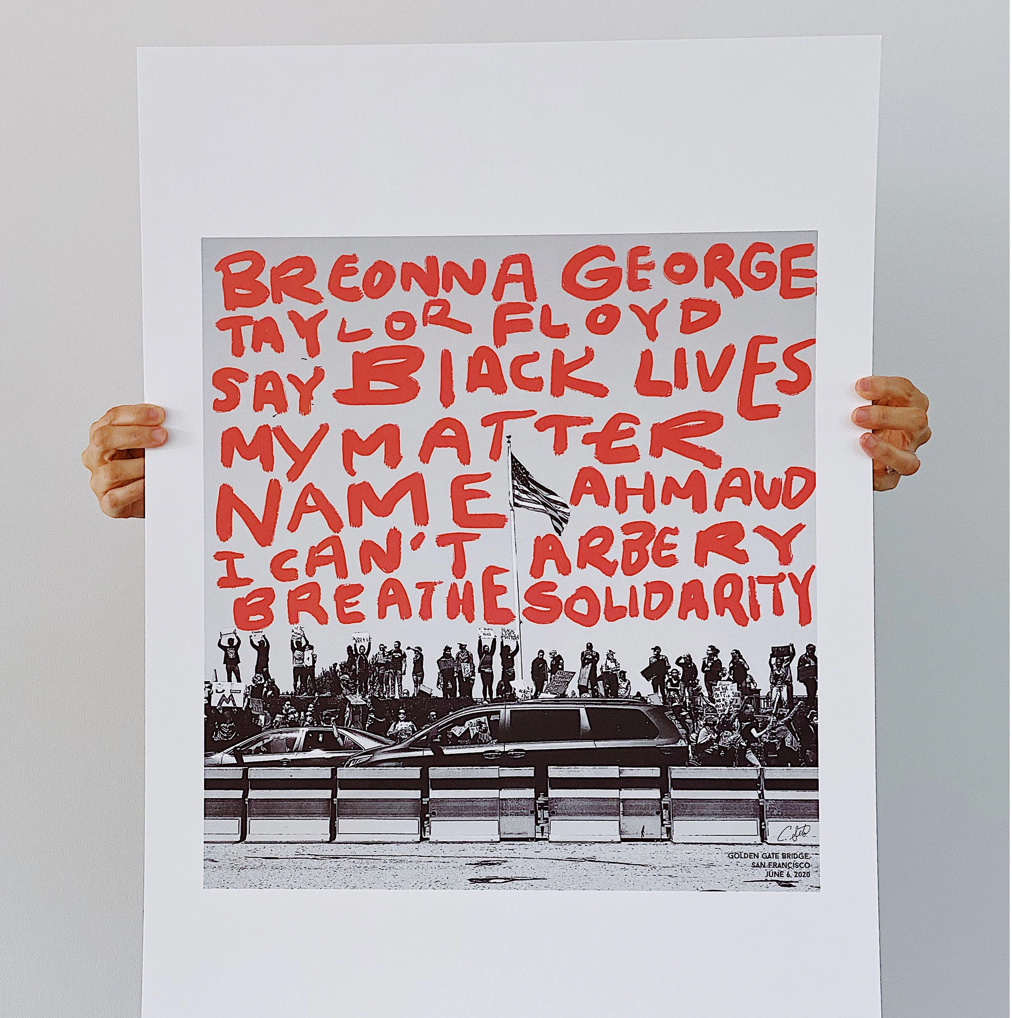 Una persona alza un grande poster con gli slogan di Black Lives Matter