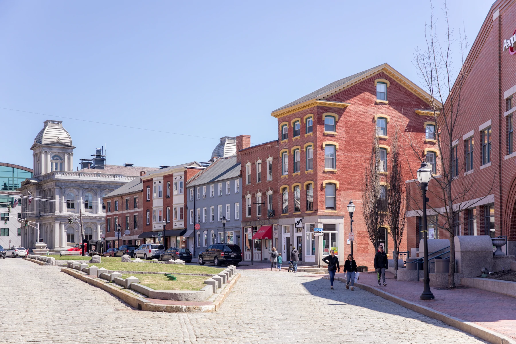 Plan d'ensemble d'une rue pavée, d'une rangée de bâtiments en briques et d'un large terre-plein herbeux à Portland, dans le Maine.