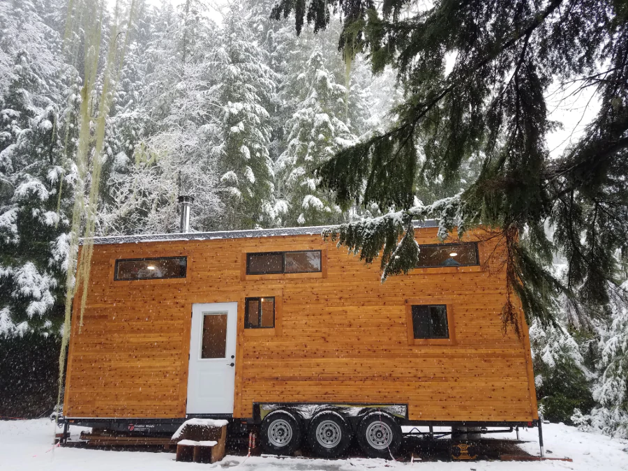 Une petite maison située dans la forêt en hiver