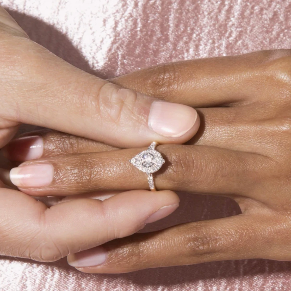 Une personne passe la bague Mia de Stone and Strand au doigt d'une autre personne.