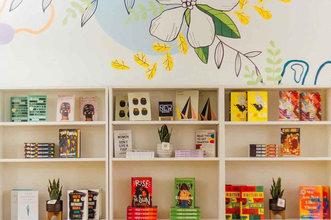 Un intérieur de librairie avec des étagères contenant des livres et une peinture murale peinte sur le mur