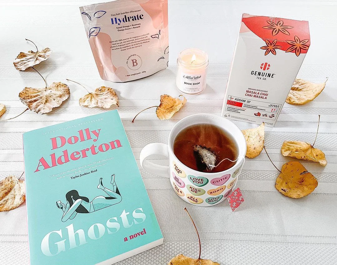 Un livre intitulé "Ghosts" disposé sur une table avec des articles de style de vie et une tasse de thé