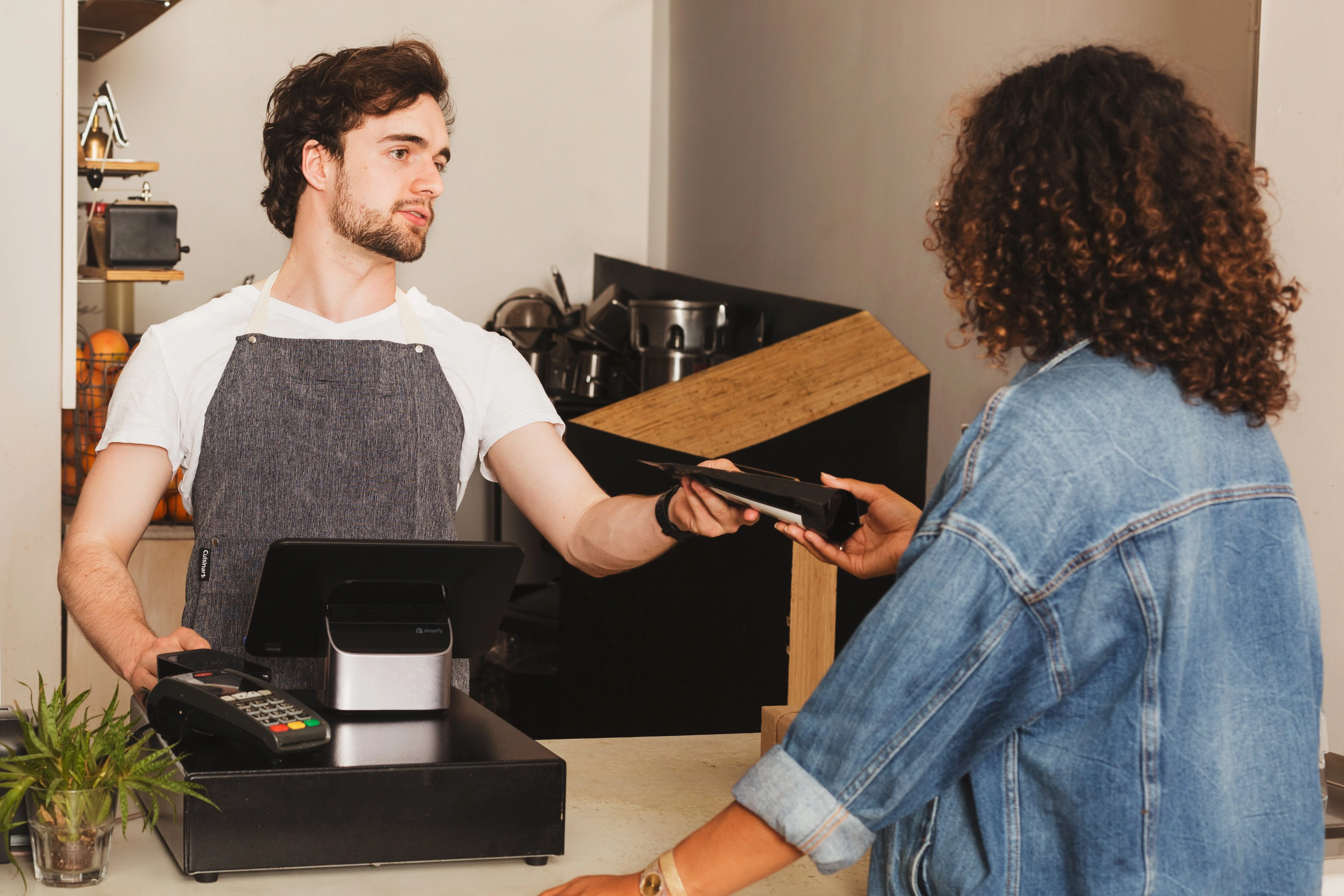 Caixa e cliente interagindo por meio de uma compra.