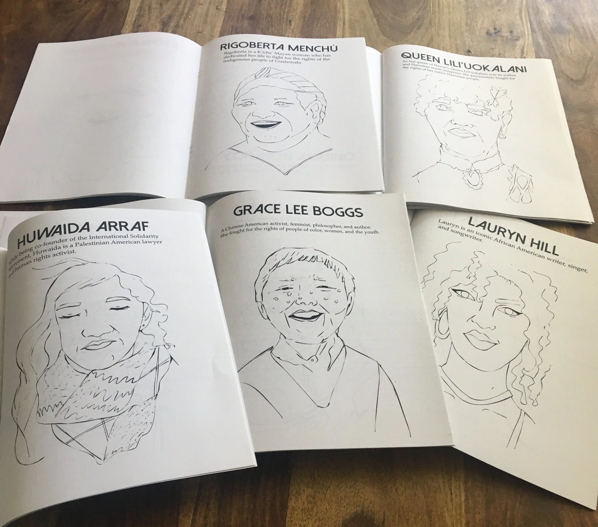 Livros para colorir com mulheres influentes de cor abertas sobre a mesa