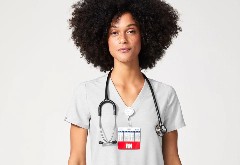 Portrait d'une femme portant des gommages médicaux FIGS et un badge d'infirmière