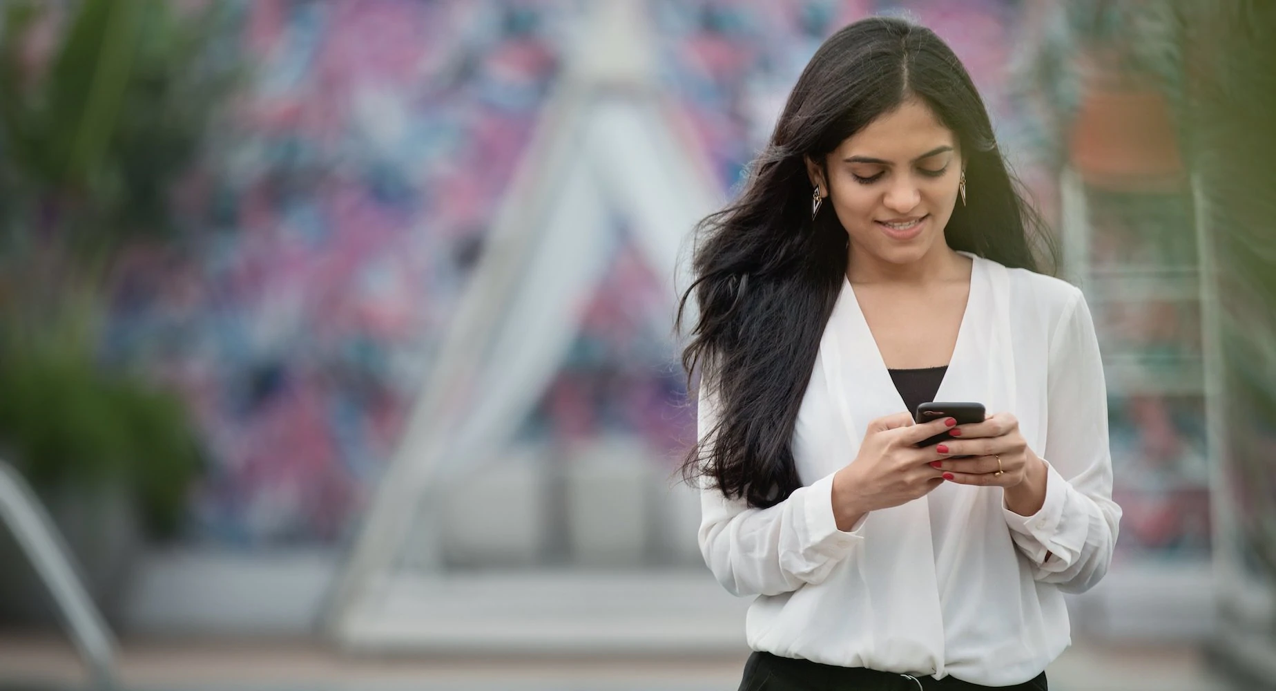 Seorang wanita mengirim pesan SMS di ponselnya