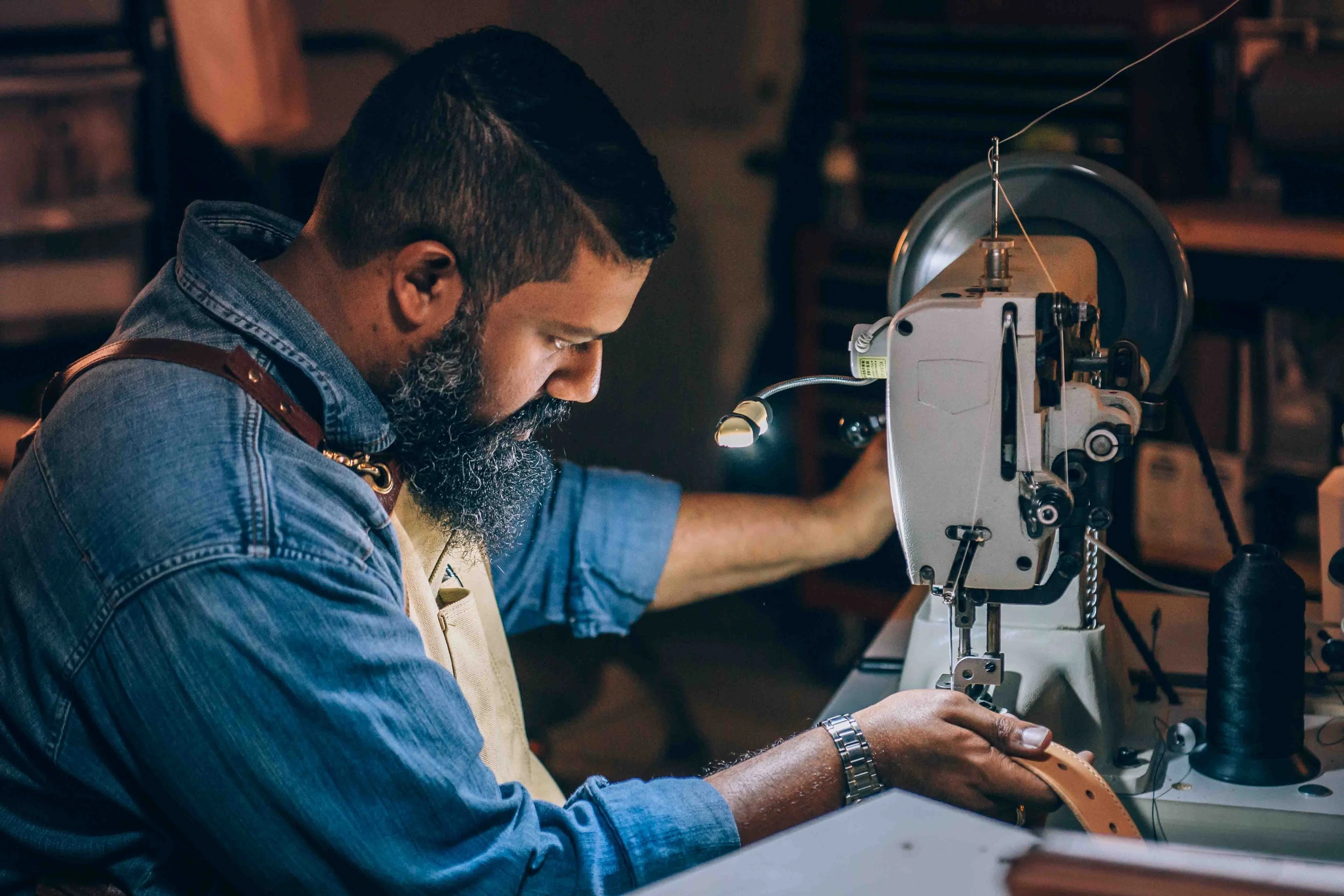 Uma pessoa trabalha em uma máquina de costura industrial