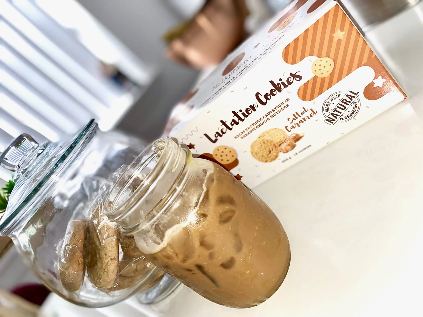 Alcuni biscotti per l'allattamento di Milky Mama insieme a una tazza di caffè freddo.