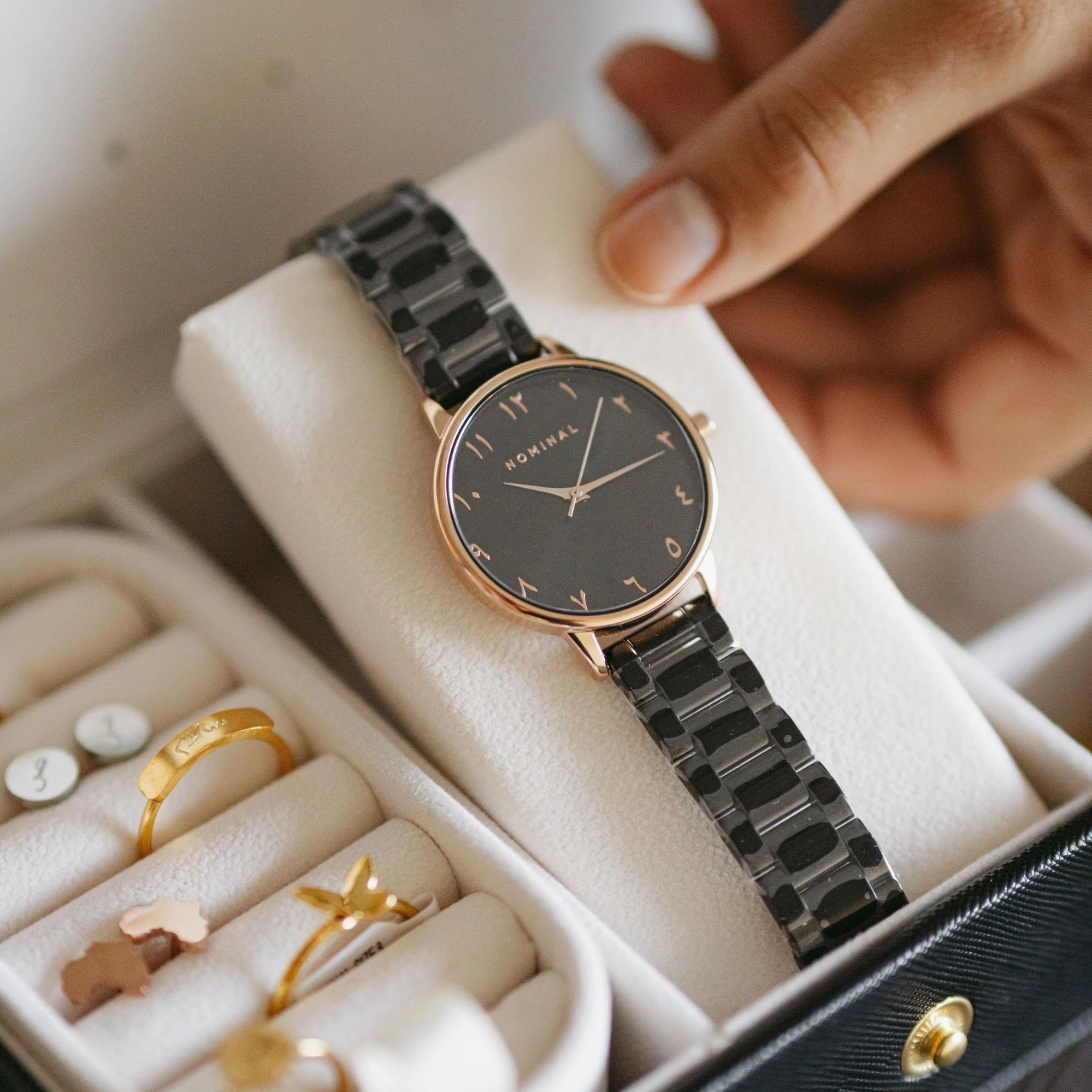 A watch, rings, and earrings in a jewelry box.