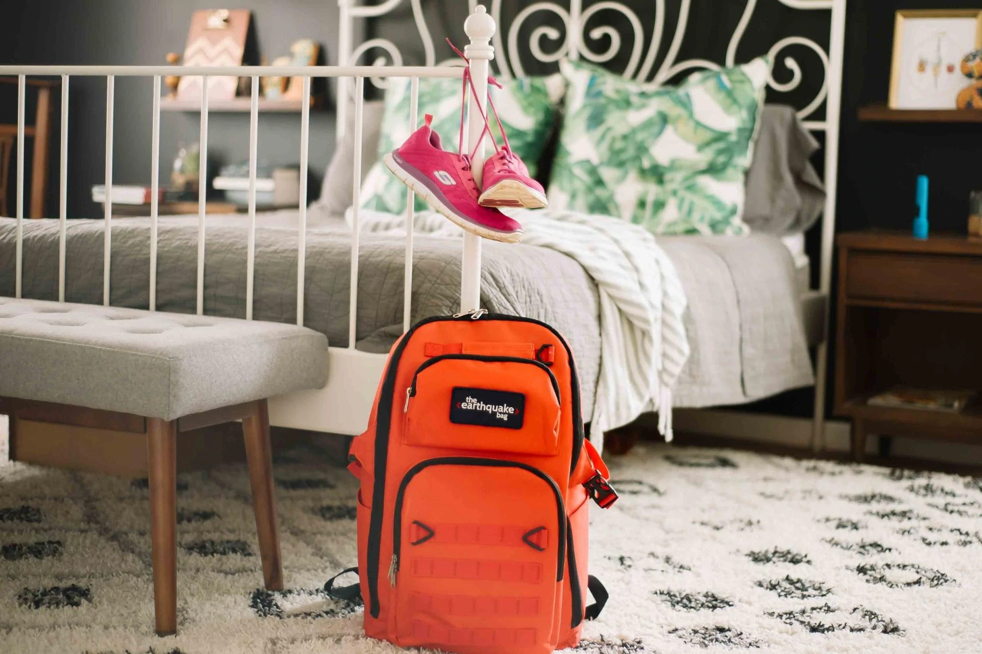 A Redfora earthquake bag rests against a bed.