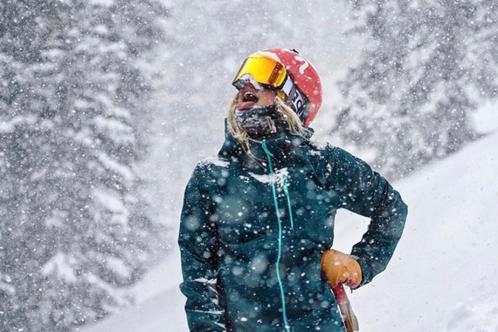 una sciatrice sullo sfondo di colline innevate indossa una maschera Glade Optics.