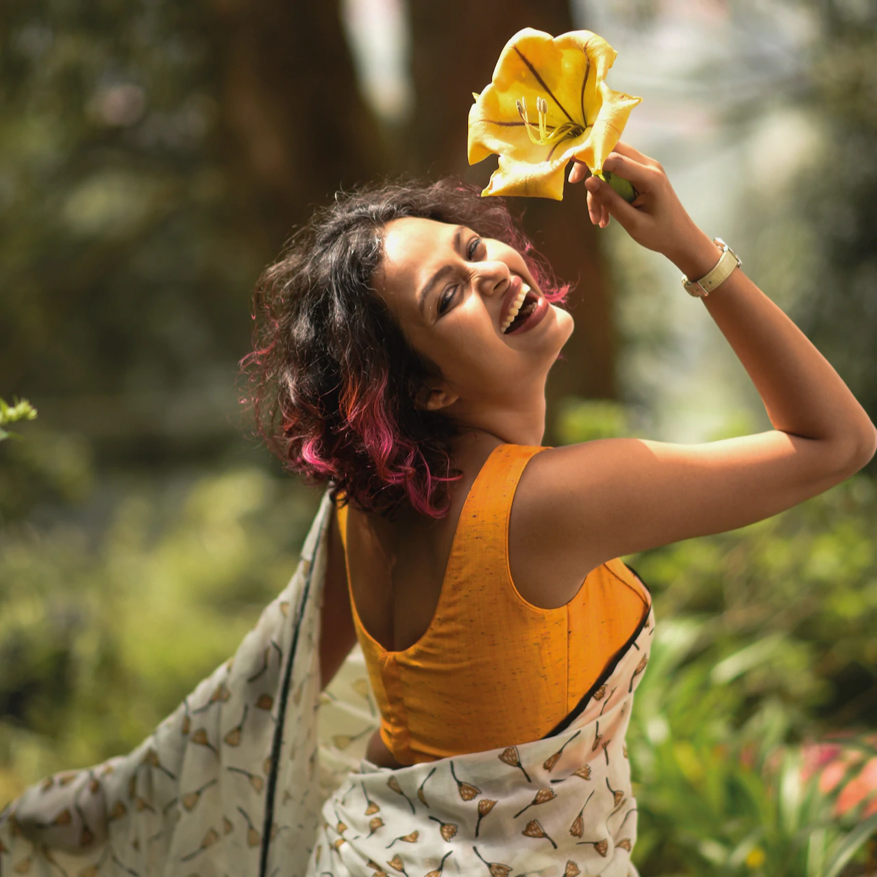 Sujata models a floral saree along with a bright yellow top.