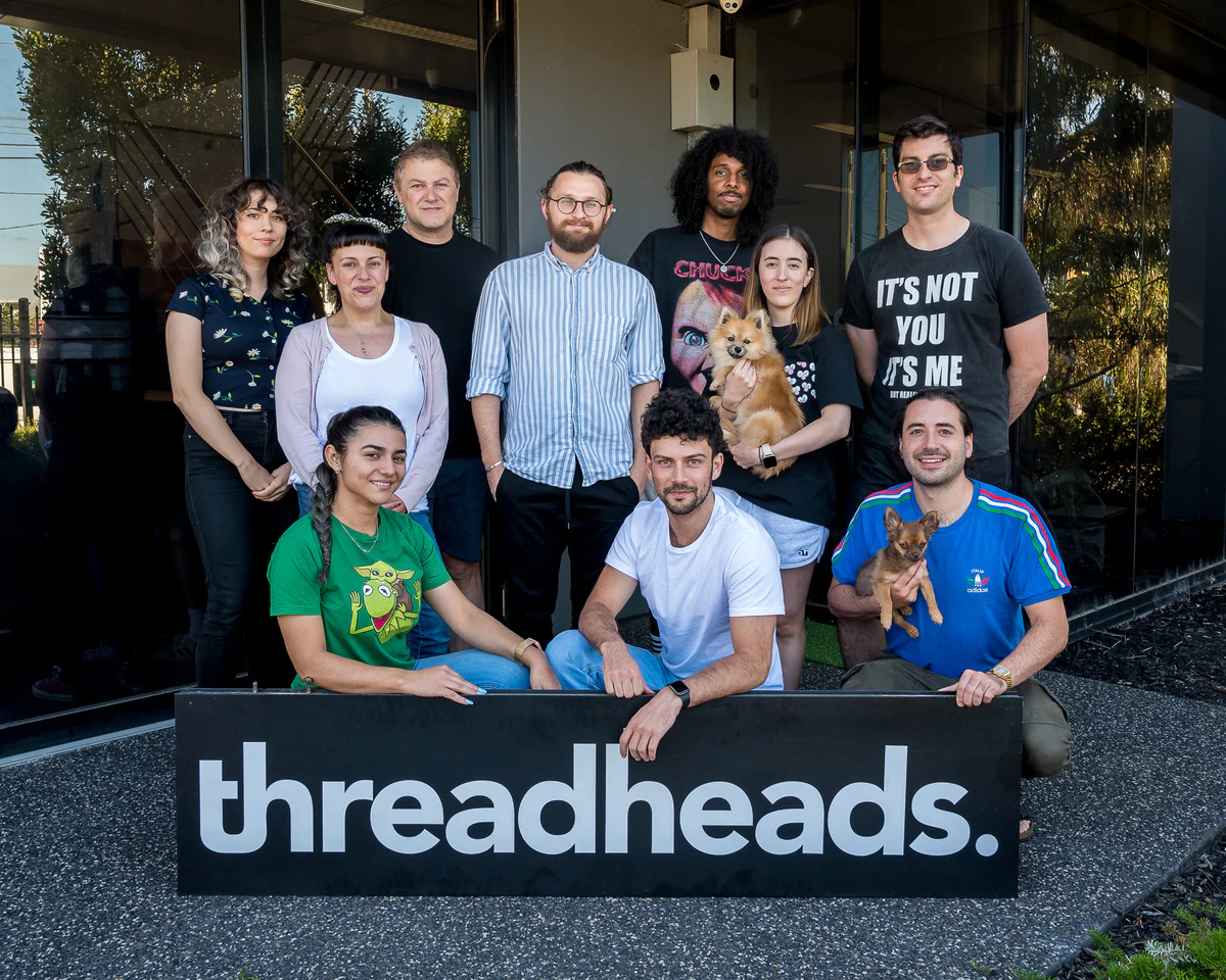 Tim di belakang Threadheads di depan kantor mereka dengan tanda Threadheads di depan grup.