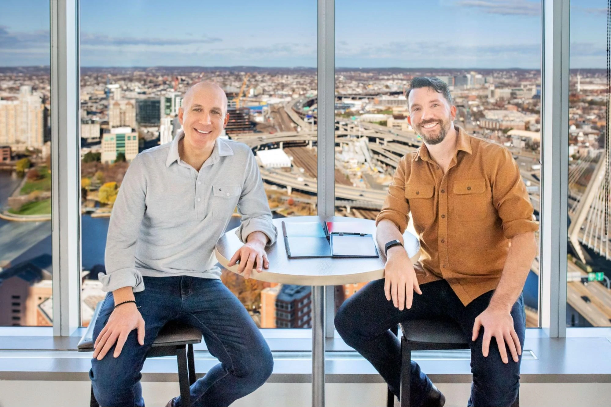 Joe Lamey und Jake Epstein sitzen mit ihren Rocketbooks an einem Schreibtisch.