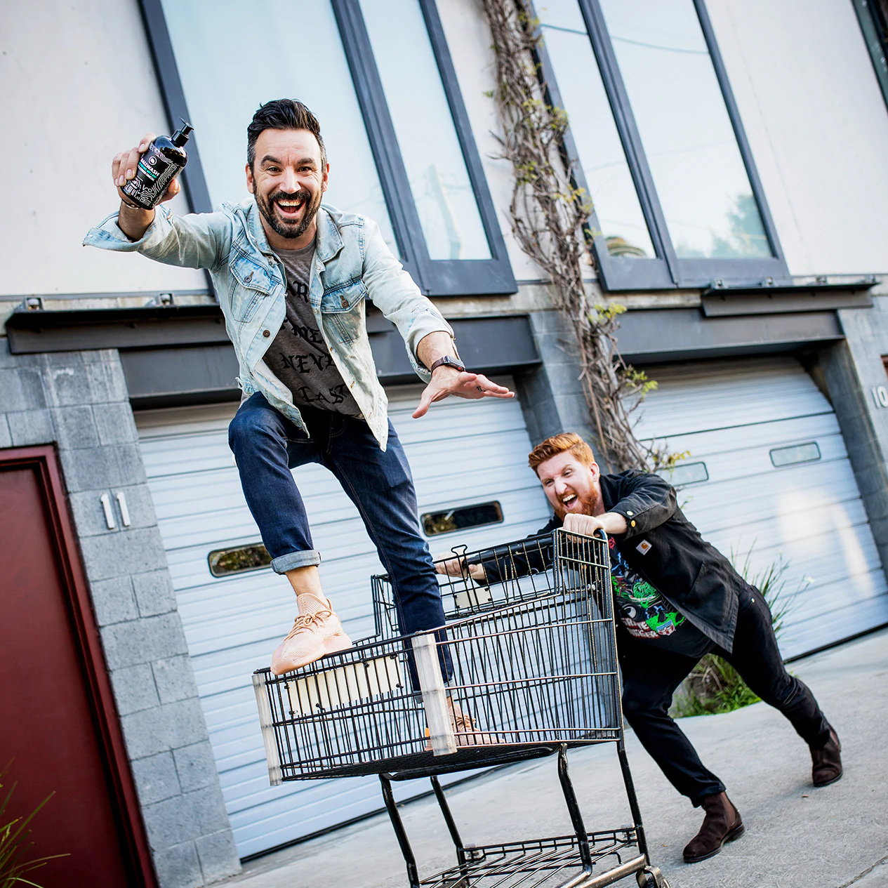 Adam Hendle steht in einem Einkaufswagen, der von einem Freund geschoben wird, und hält ein Ballsy-Produkt in der Hand.