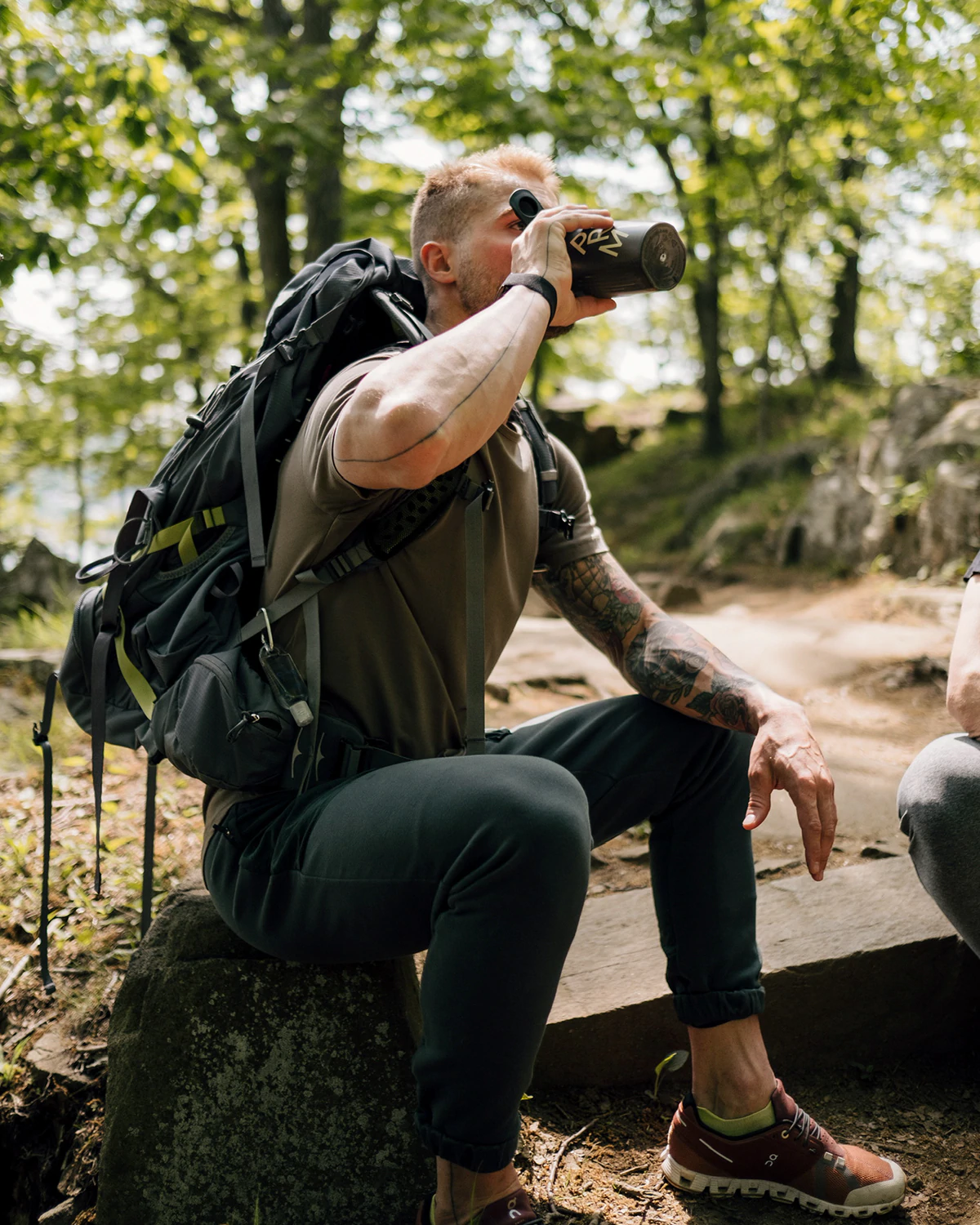 A male model in an outdoors setting drinking a nutrition mix from Promix.