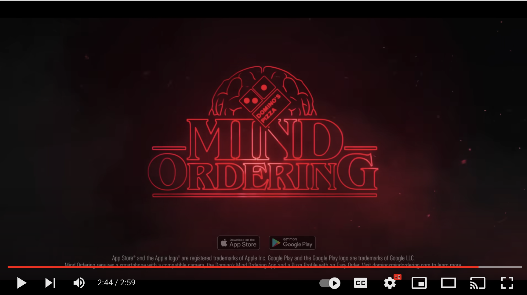 새로운 Mind Ordering 앱을 홍보하는 Domino's의 YouTube 동영상 스크린샷. 비디오의 배경은 1986년 호킨스 연구소입니다. 또한 지역 도미노에서 두 명의 기묘한 이야기 ​​스타가 등장합니다.