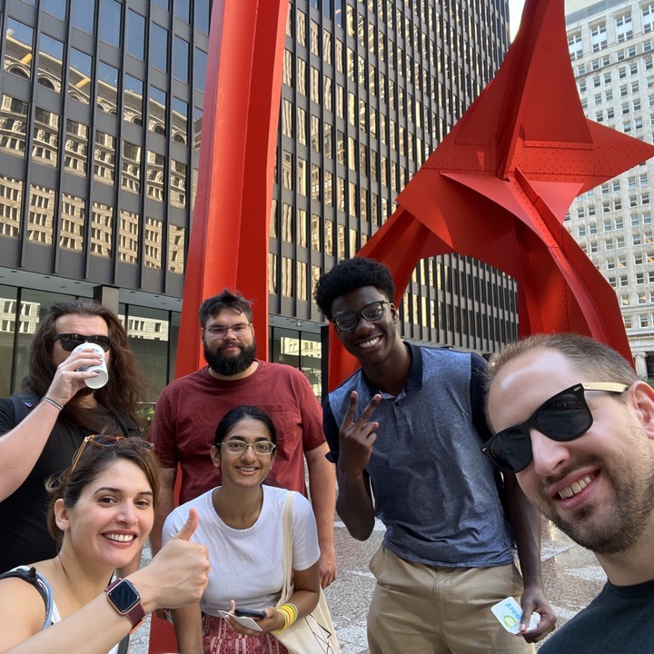 Foto de los compañeros de trabajo de Julius Boating y Sprout fuera de la estatua de Calder's Flamingo en el centro de Chicago