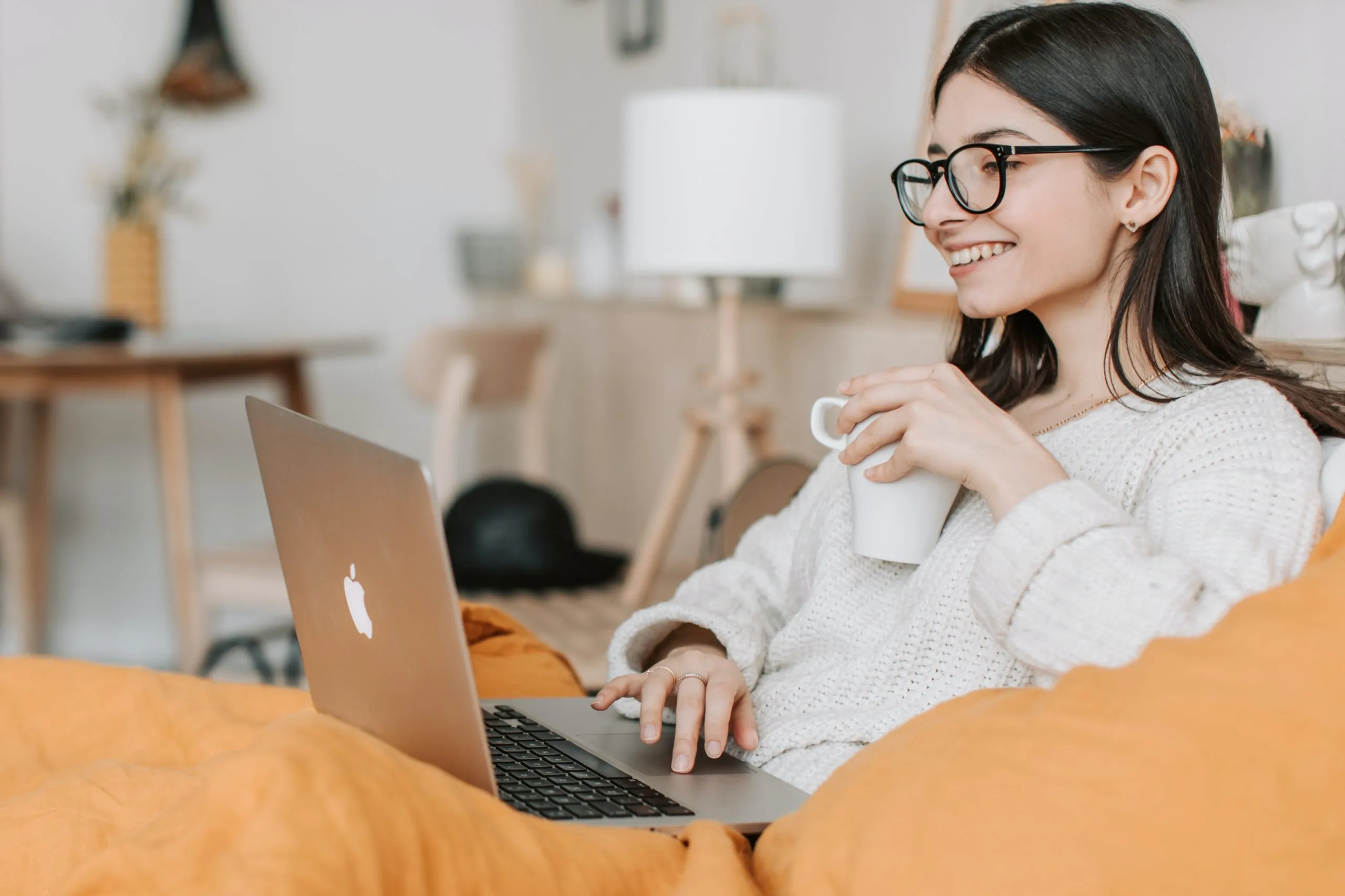 Femme buvant un café tout en utilisant un ordinateur portable