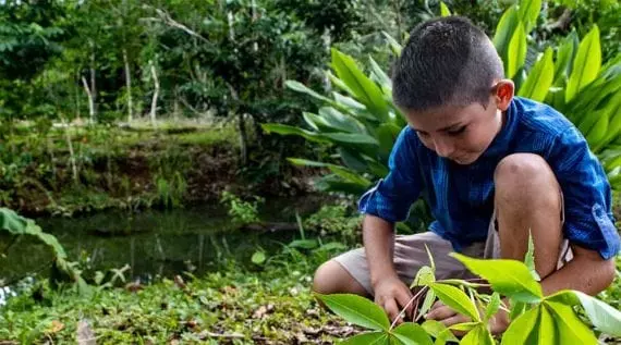 Fotografie cu un băiat lângă un râu în, probabil, Costa Rica